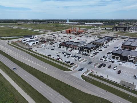 High aerial view of the Kettlestone Central district in Waukee, with wood-framed multifamily construction rising beyond Kettlestone Social