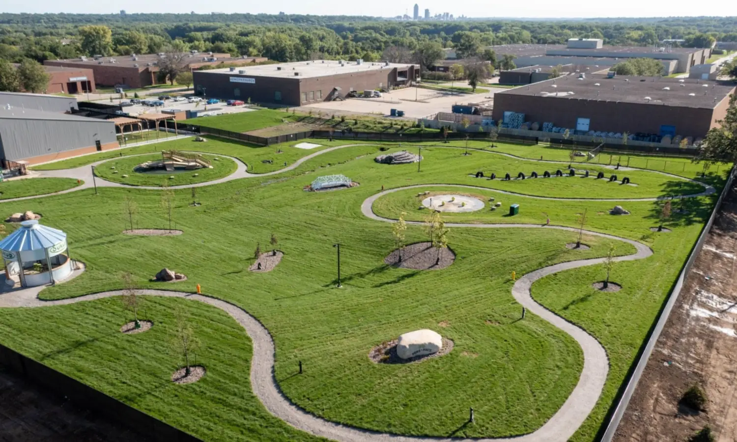 Aerial view across a Des Moines metro commercial district with the downtown skyline on the horizon