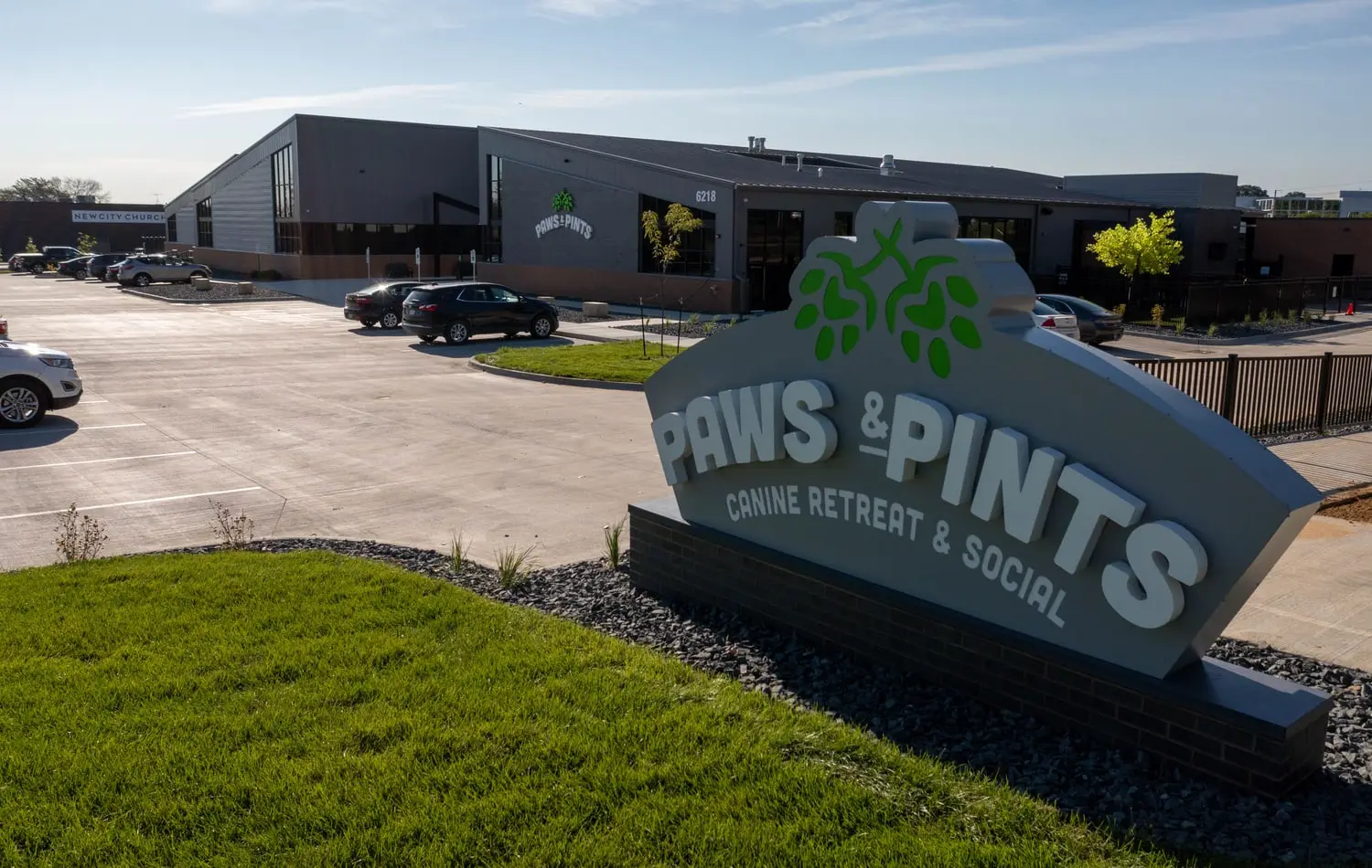 3 September 2022: the finished Paws & Pints monument sign reading Canine Retreat and Social, in front of the completed building with cars in the car park