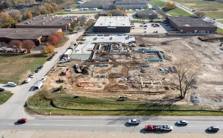 2 November 2021 — foundation walls and slab sections poured across the building footprint, fall color in the tree line