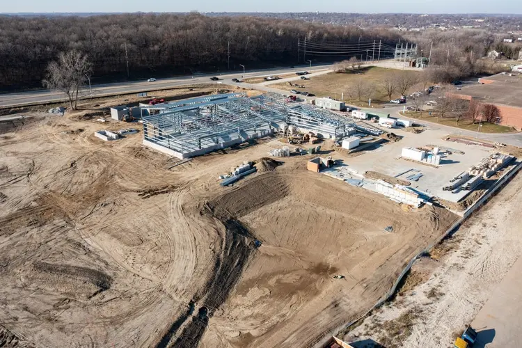 8 December 2021 — structural steel erected across the full footprint, the frame legible against bare ground