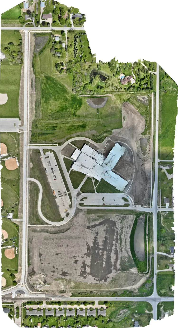 Aerial site map, 11 May 2024 — lots paved and striped, drives complete, turf establishing across the north of the site